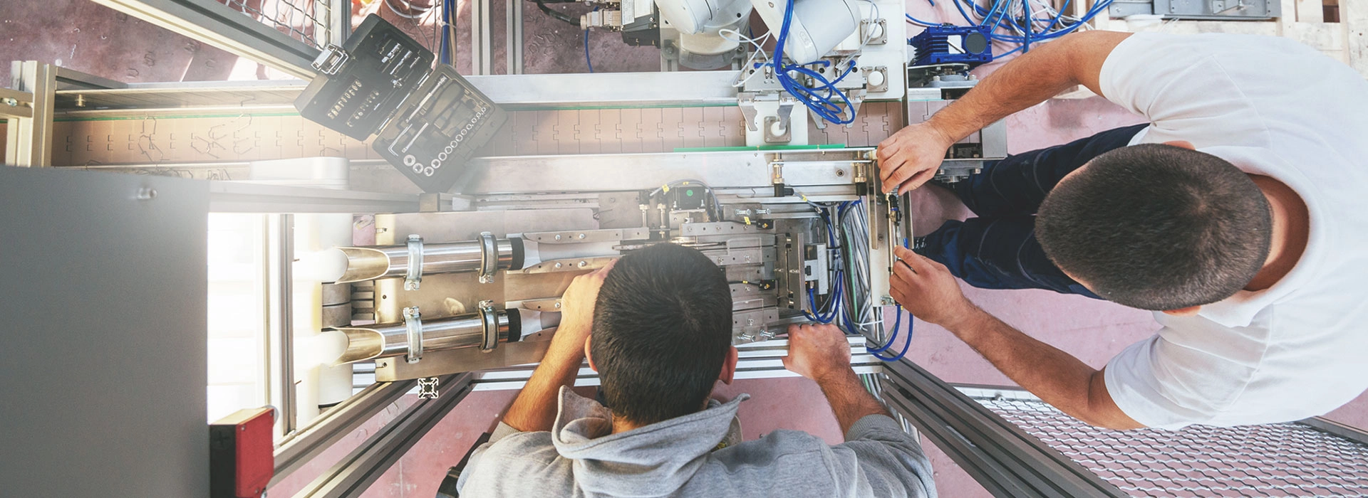 Two men working on the maintenance of a machine.
